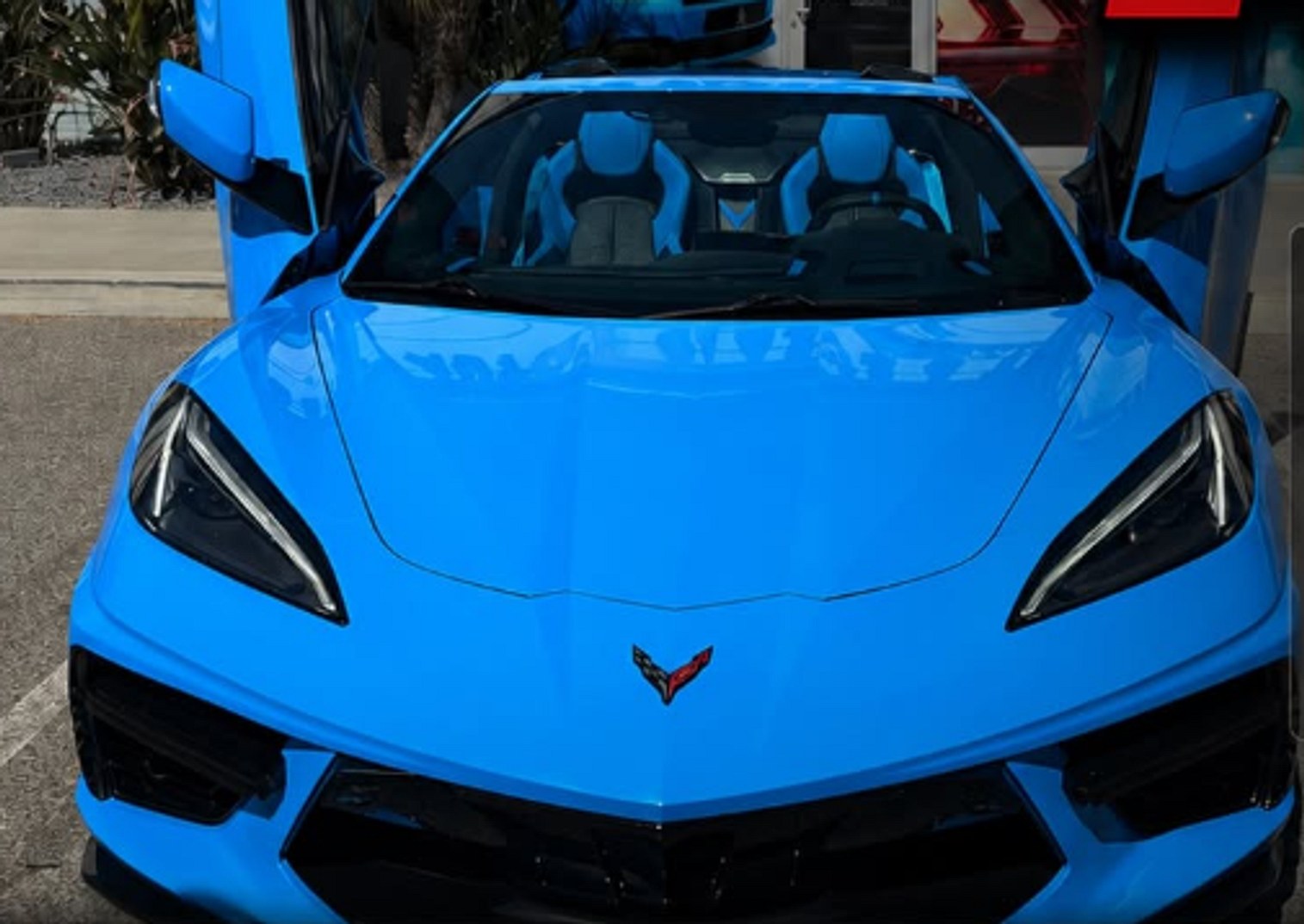 Rapid blue Corvette C8 with doors raised, getting window tint at Auto Glass & Tint Factory