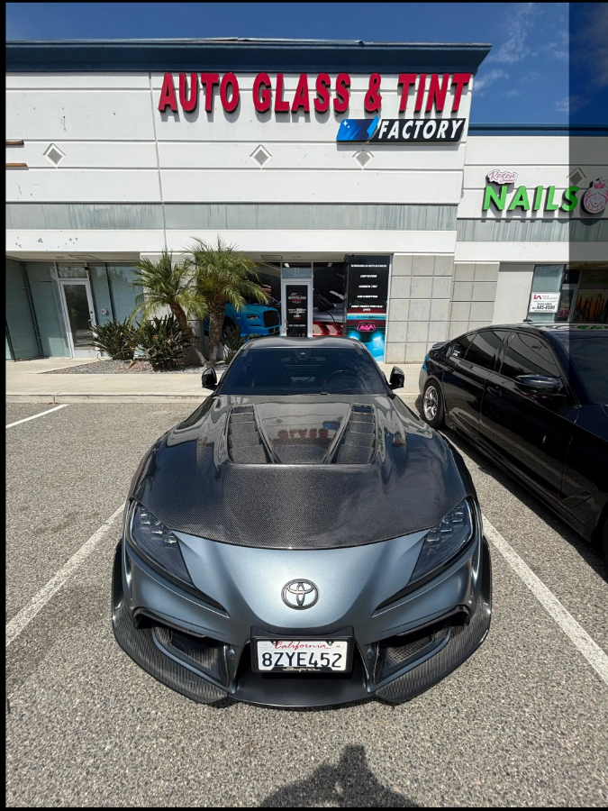 Toyota GR Supra with carbon hood and paint protection film in front of the shop